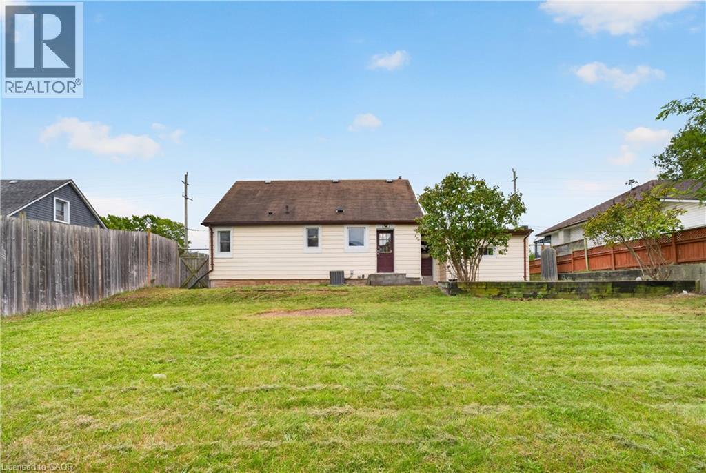 Expansive grassy yard with wood fencing and a detached structure - 176 Avalon Place, Kitchener, ON