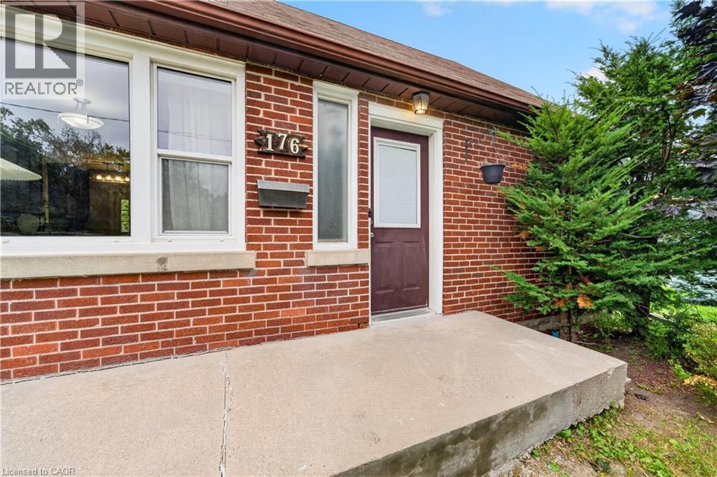 Red brick exterior with white window trim and a concrete porch - 176 Avalon Place, Kitchener, ON