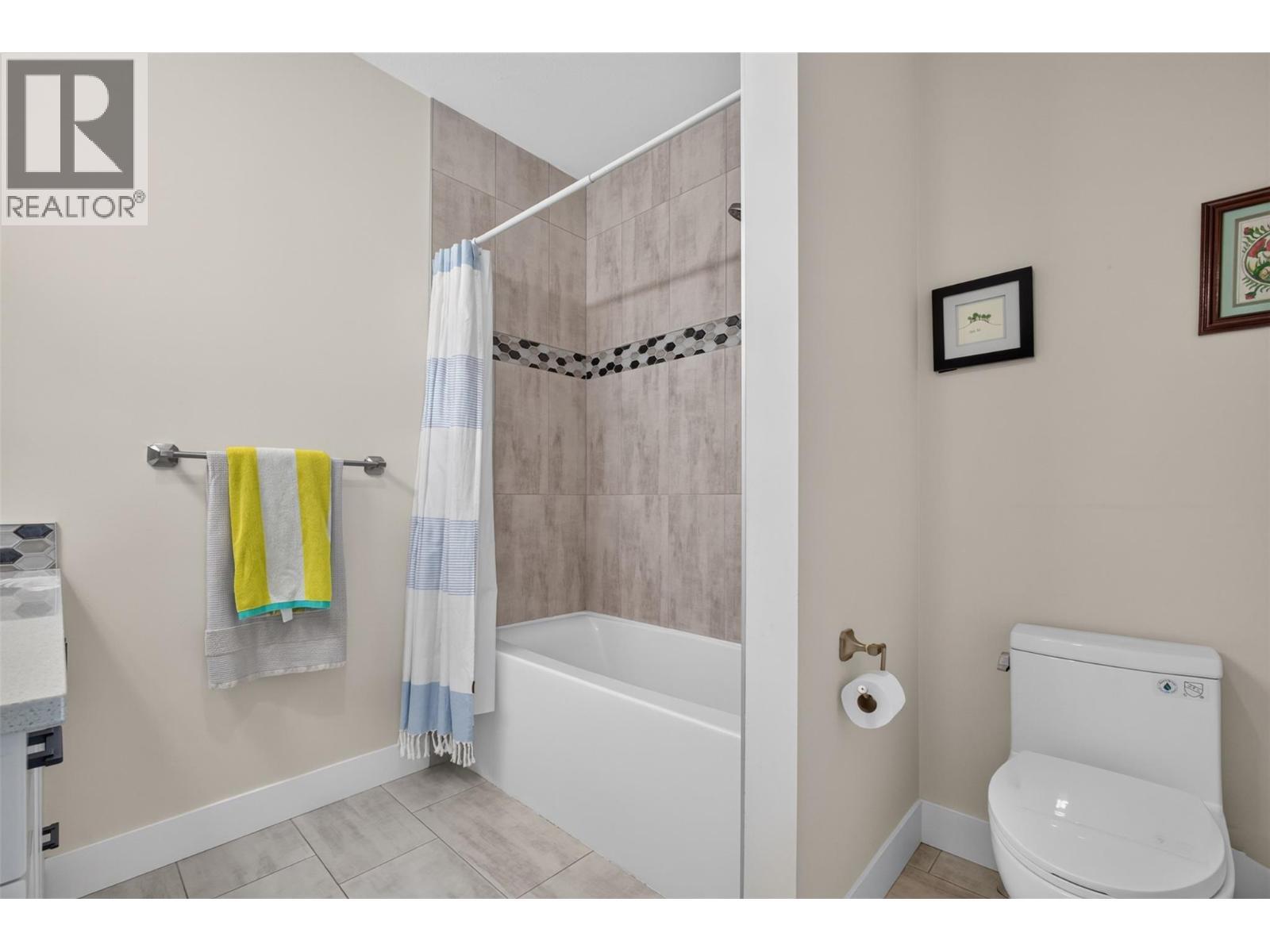Full upstairs bathroom with a tiled tub/shower surround - 2400 Hawks Boulevard, West Kelowna, BC