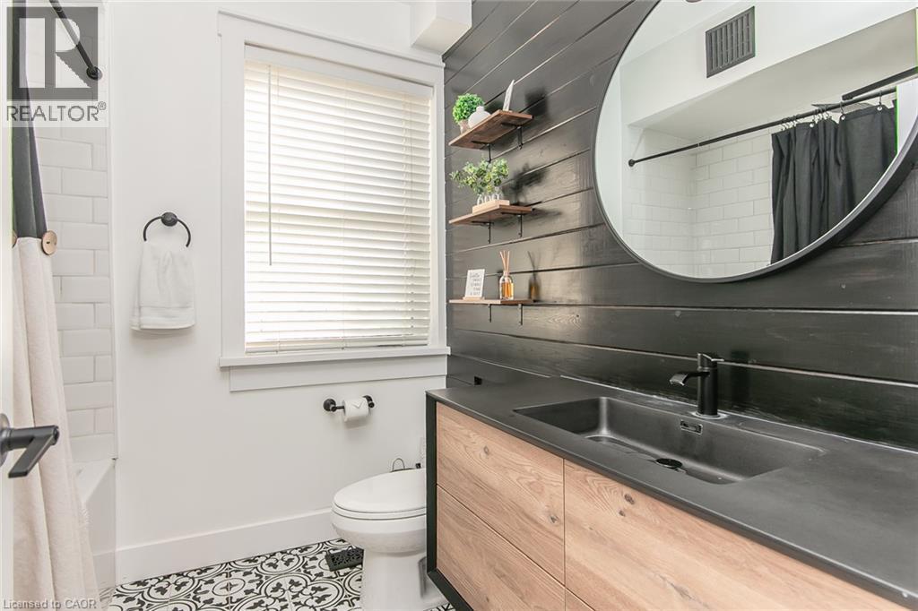 Wood-finish vanity with an integrated sink and matte black faucet - 393 Huron Street, New Hamburg, ON