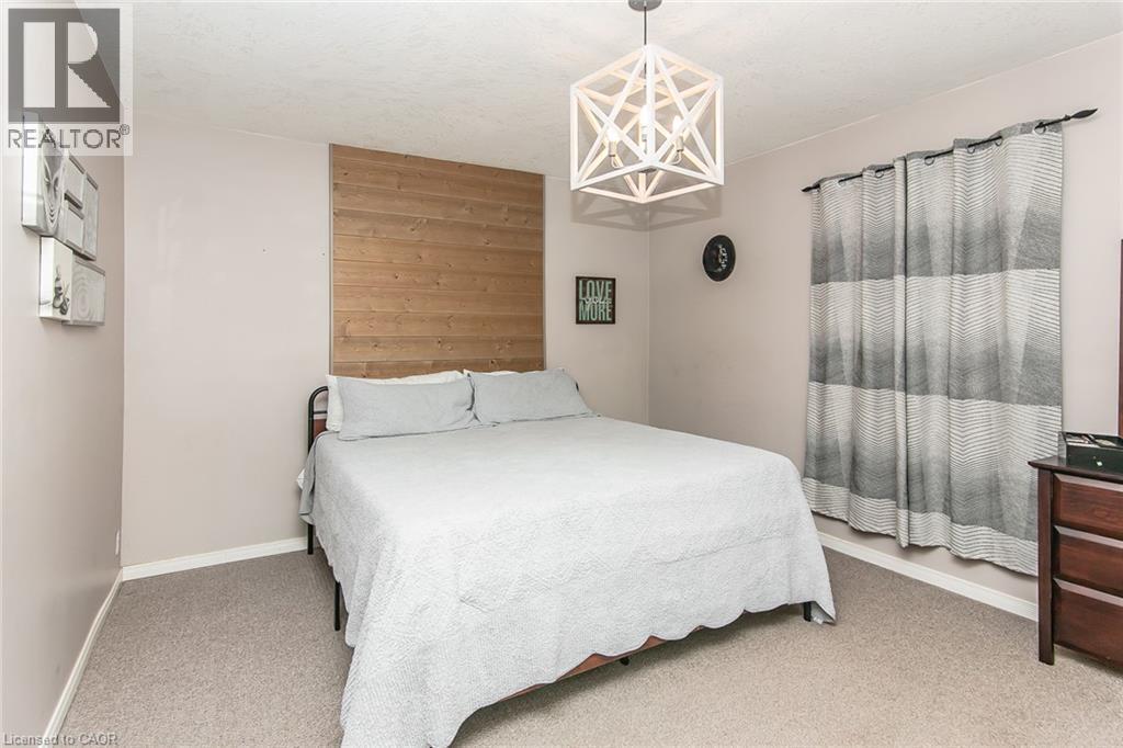 Geometric pendant light fixture, wood-finish accent wall, and neutral wall color - 393 Huron Street, New Hamburg, ON