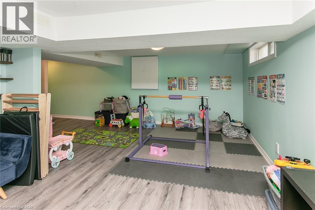 Lower-level space featuring wood-finish flooring, recessed lighting, and a window - 393 Huron Street, New Hamburg, ON