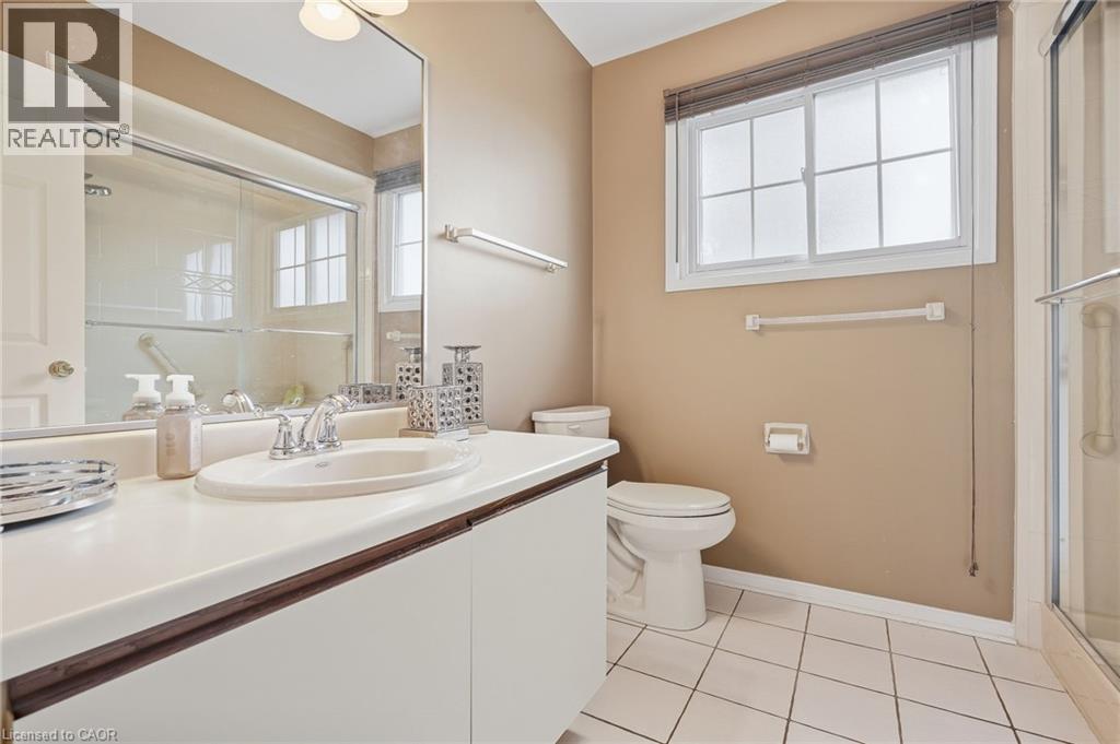 White tile flooring, single vanity with integrated sink, chrome faucet, mirrored medicine cabinet, and glass-enclosed shower - 5 Michelle Drive, St. Catharines, ON