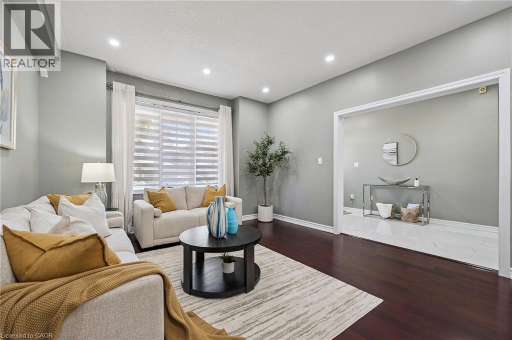 Recessed lighting illuminates the living space with dark wood-finish flooring - 154 Falconridge Drive, Kitchener, ON