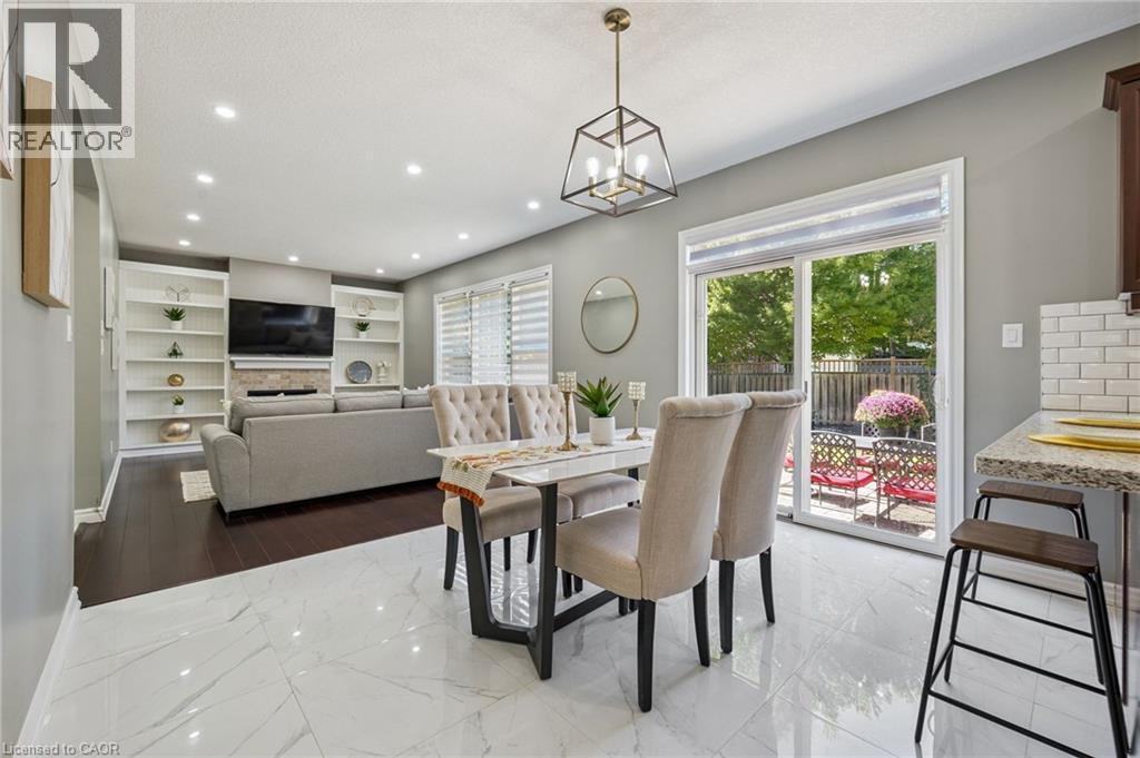 Recessed lighting throughout, built-in shelving, white subway tile backsplash, and sliding glass doors to the exterior - 154 Falconridge Drive, Kitchener, ON