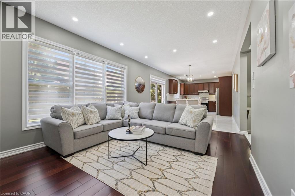 Hardwood flooring, recessed lighting, expansive windows, kitchen with shaker-style cabinetry, and pendant light fixture - 154 Falconridge Drive, Kitchener, ON