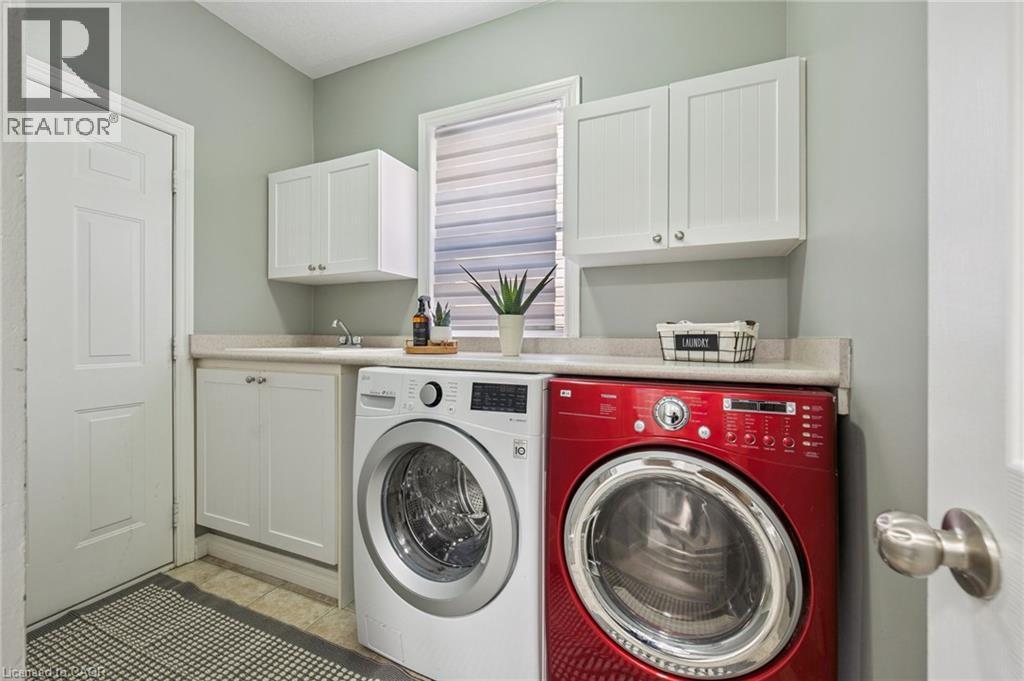 Built-in white cabinetry, light-toned countertop, and a utility sink - 154 Falconridge Drive, Kitchener, ON