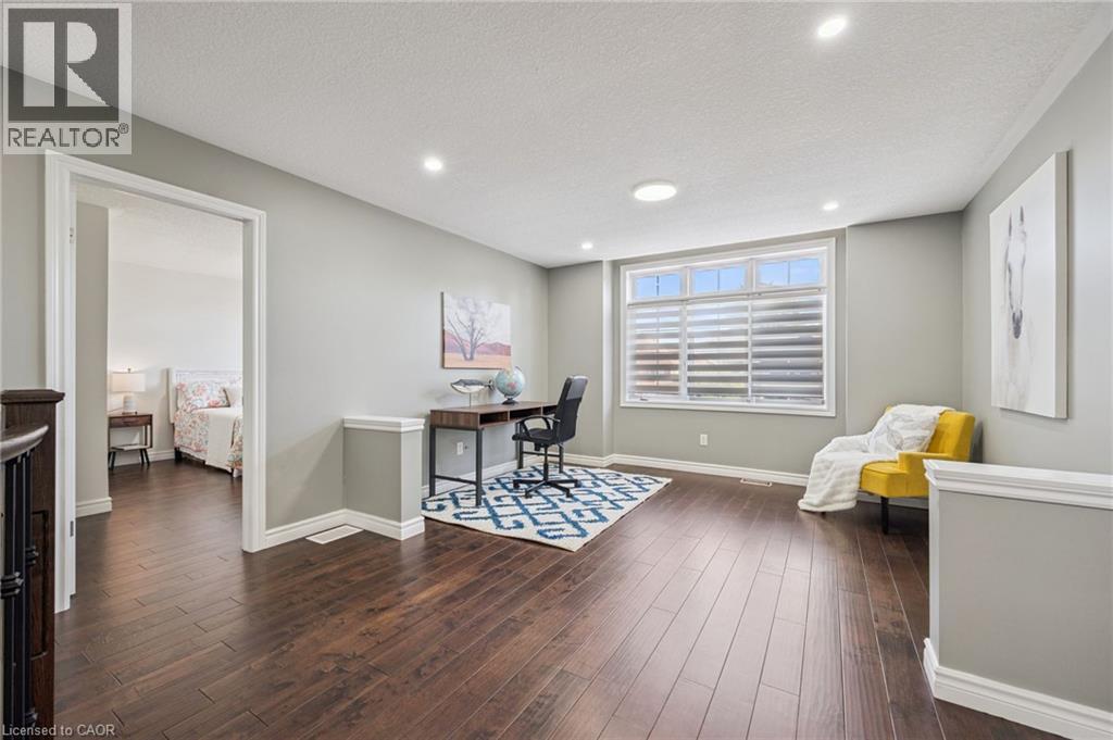 Hardwood flooring, recessed lighting, large window, chair rail molding, and an open doorway - 154 Falconridge Drive, Kitchener, ON