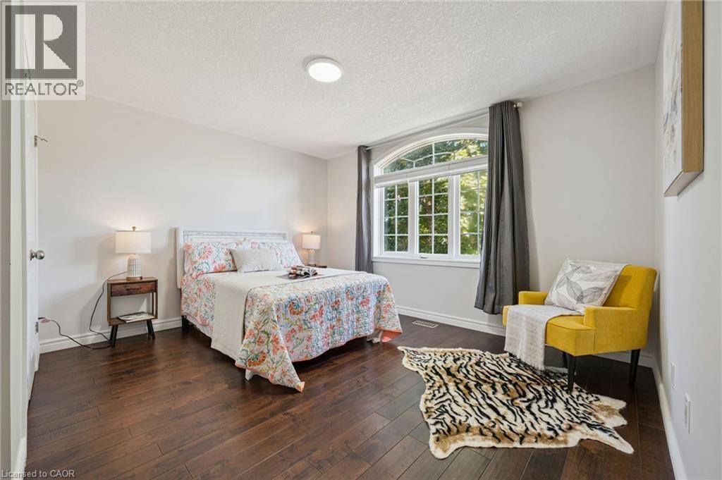 Dark wood-finish flooring with white baseboards - 154 Falconridge Drive, Kitchener, ON