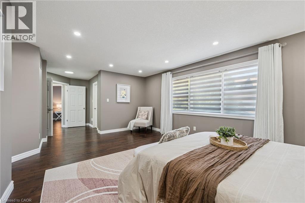 Recessed ceiling lighting, wood-finish flooring, broad window with horizontal blinds, white door, and neutral-toned walls - 154 Falconridge Drive, Kitchener, ON