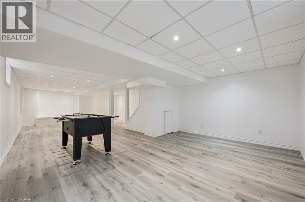 Spacious lower level featuring wood-finish flooring, recessed lighting, and a white drop ceiling - 154 Falconridge Drive, Kitchener, ON