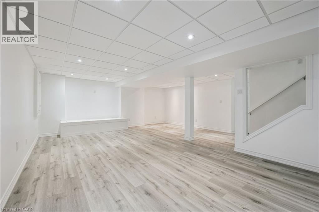 Spacious interior featuring light wood-finish flooring, recessed lighting, drop ceiling, and a built-in bench - 154 Falconridge Drive, Kitchener, ON