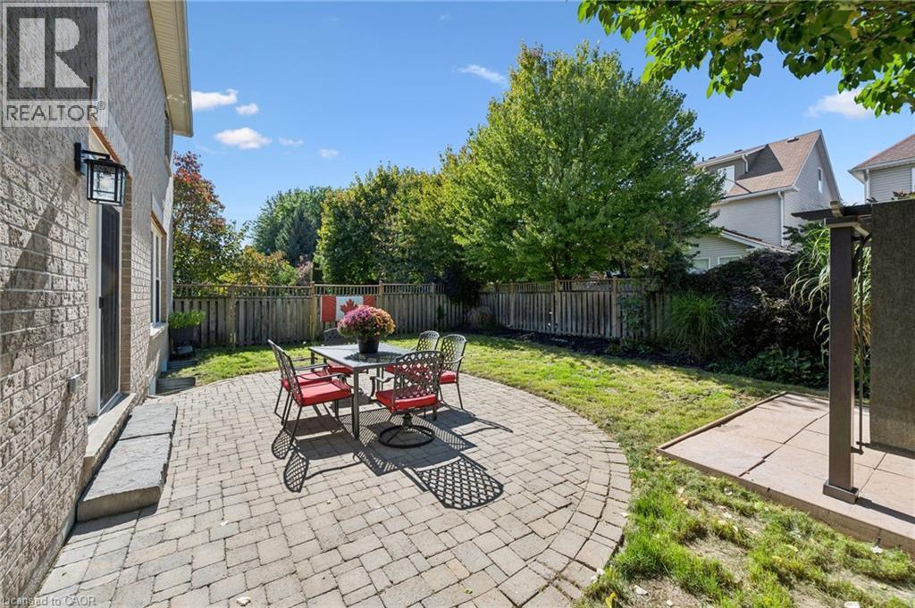 Paved patio with a curved edge, brick exterior, and a fenced perimeter - 154 Falconridge Drive, Kitchener, ON