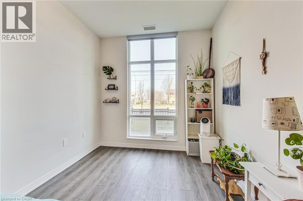 Wood-finish flooring, white walls, and a large multi-pane window - 2750 King Street E Unit# 103, Hamilton, ON
