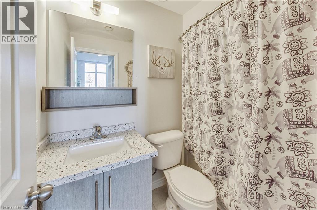 Vanity with a speckled countertop, undermount sink, and two-door cabinetry - 2750 King Street E Unit# 103, Hamilton, ON