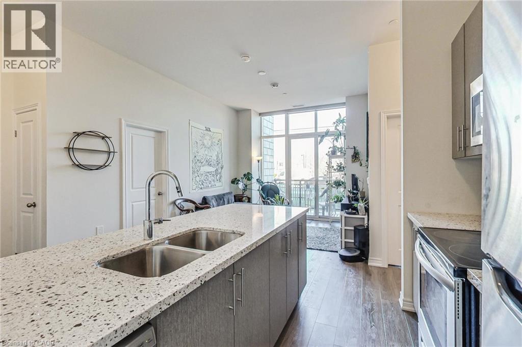 Kitchen island with dual basin stainless steel sink, gooseneck faucet, and light-toned speckled countertop - 2750 King Street E Unit# 103, Hamilton, ON