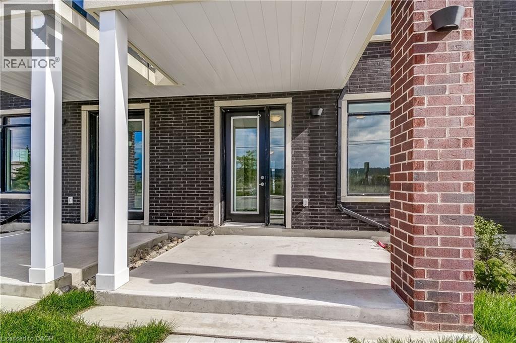Brick exterior facade with multiple large windows and glass-panel doors - 58 Windward Drive, Grimsby, ON