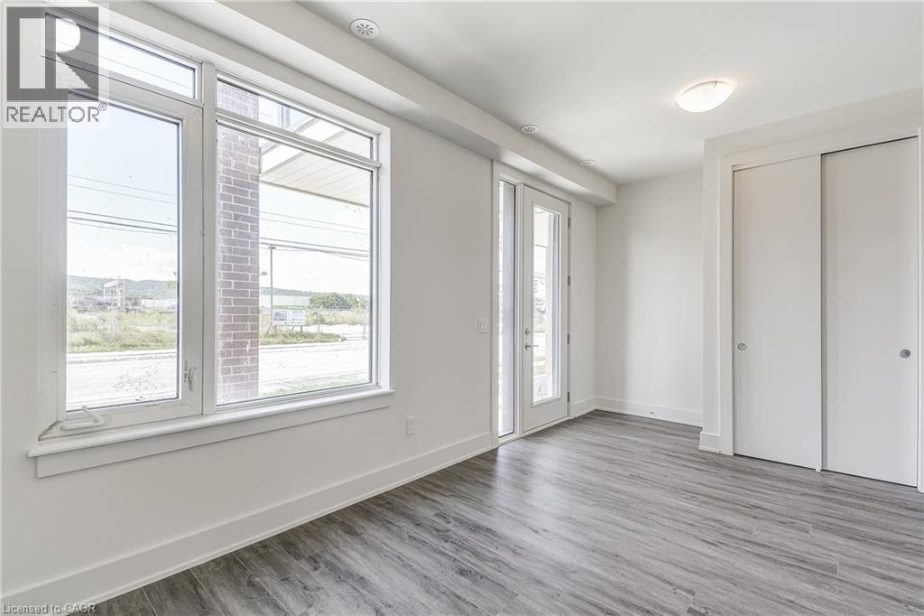 Wood-finish flooring, white walls, large windows, recessed lighting, and a sliding door closet - 58 Windward Drive, Grimsby, ON
