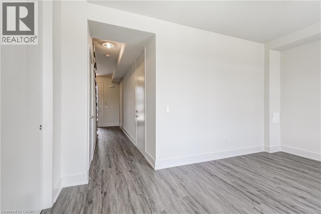 Light wood-finish flooring with white baseboards throughout - 58 Windward Drive, Grimsby, ON