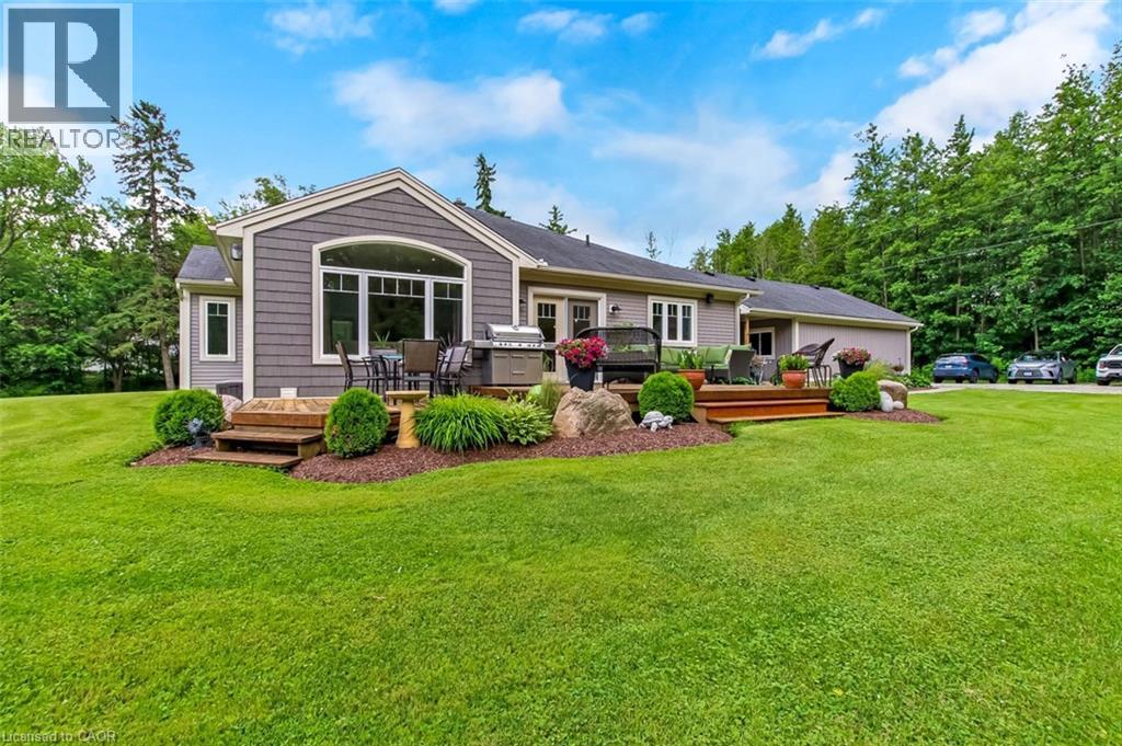 Enjoy the added living space on the large back deck, overlooking the landscaped yard, complete with nat. gas BBQ line and multiple access points to the yard and side patio. - 59 Decou Road, Simcoe, ON