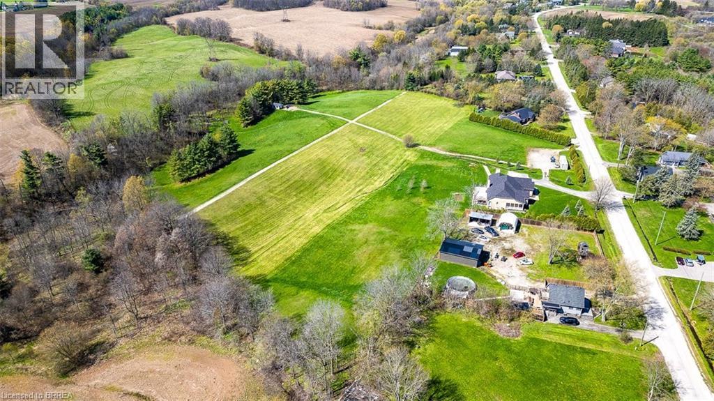 Expansive property featuring a mix of cleared grassland and mature trees - 47 River Road, Brantford, ON