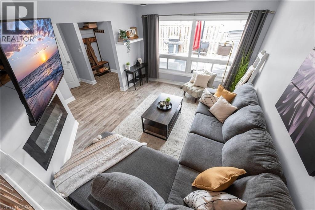Living area featuring wood finished floors and baseboards - 5 Viking Court Unit# 301, Grimsby, ON