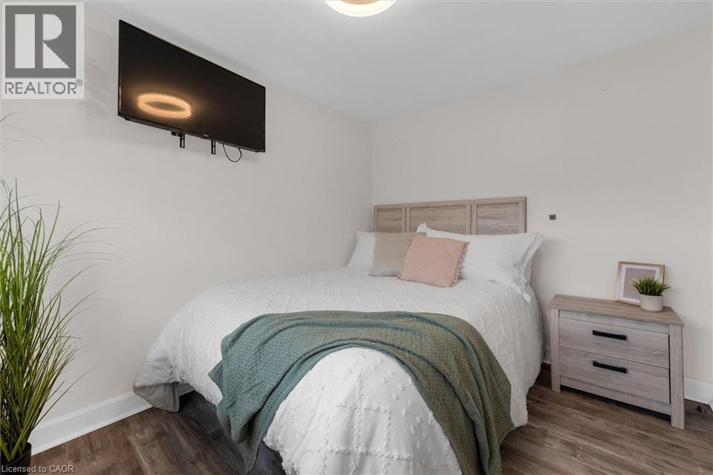 Bedroom featuring baseboards and dark wood-type flooring - 5 Viking Court Unit# 301, Grimsby, ON
