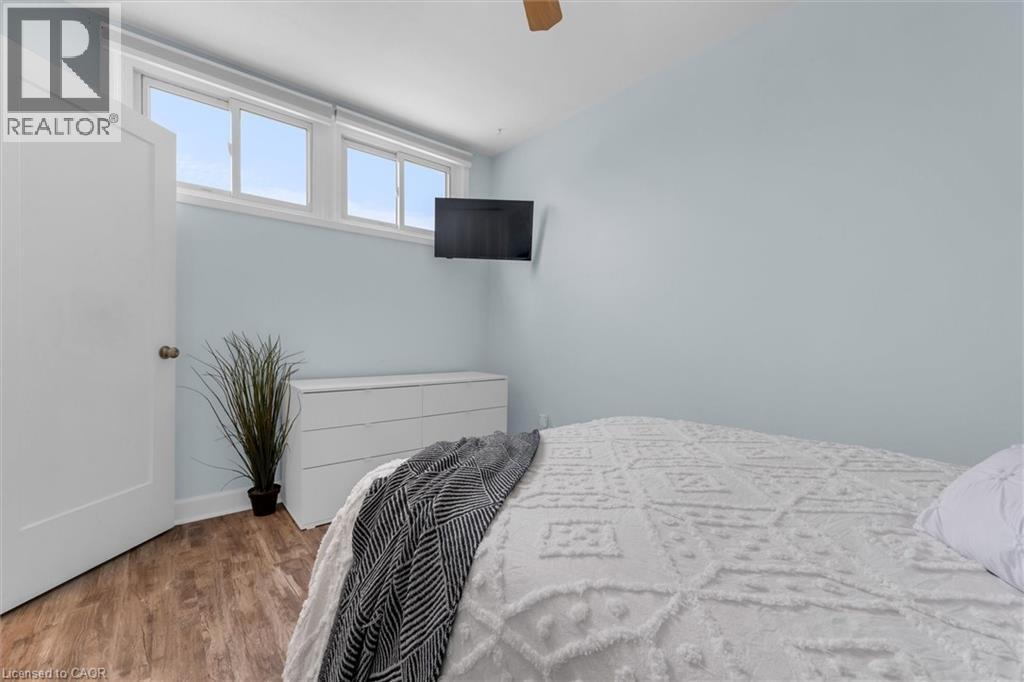 Bedroom featuring wood finished floors and a ceiling fan - 5 Viking Court Unit# 301, Grimsby, ON