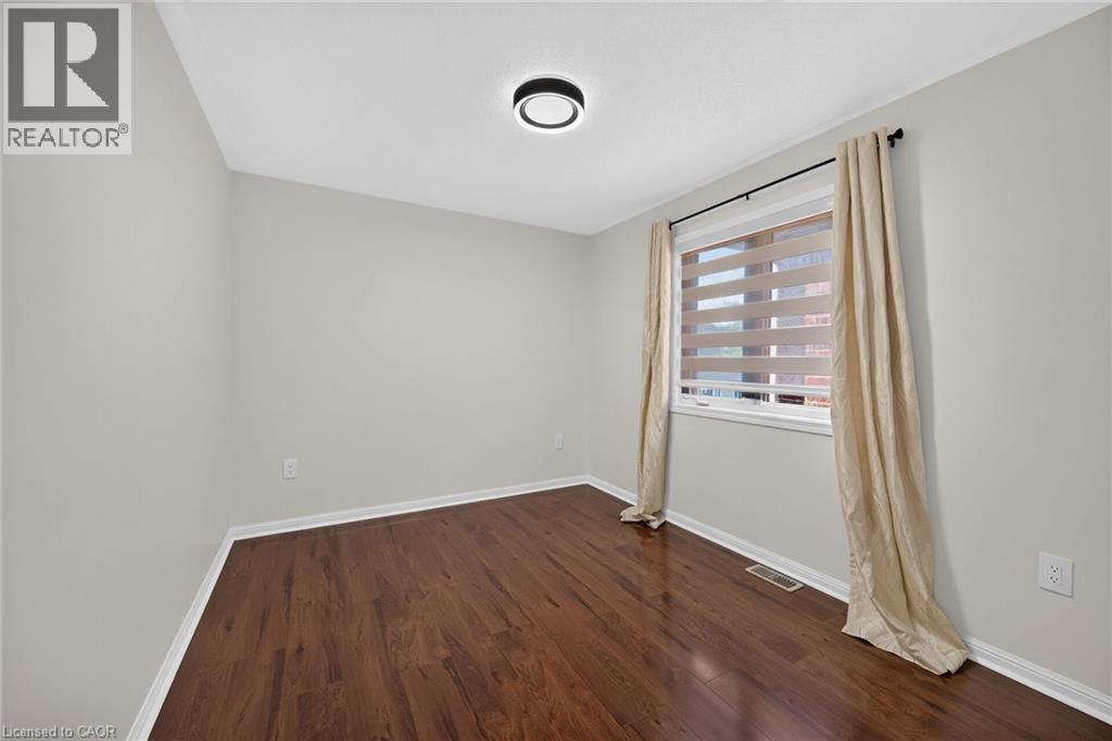 Wood-finish flooring, neutral wall tones, recessed window, and contemporary ceiling light fixture - 103 Emick Drive, Ancaster, ON