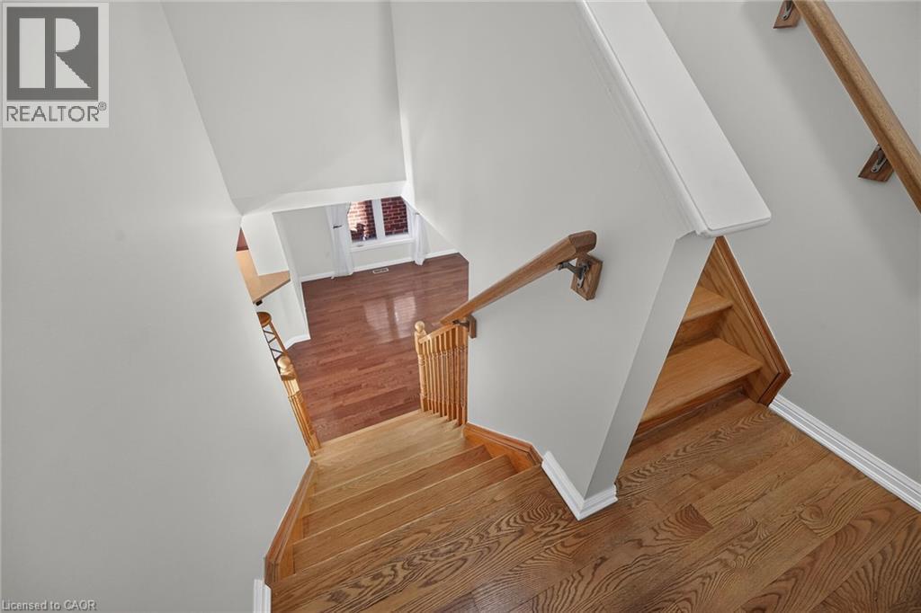 Hardwood flooring and staircase with natural wood banister - 103 Emick Drive, Ancaster, ON