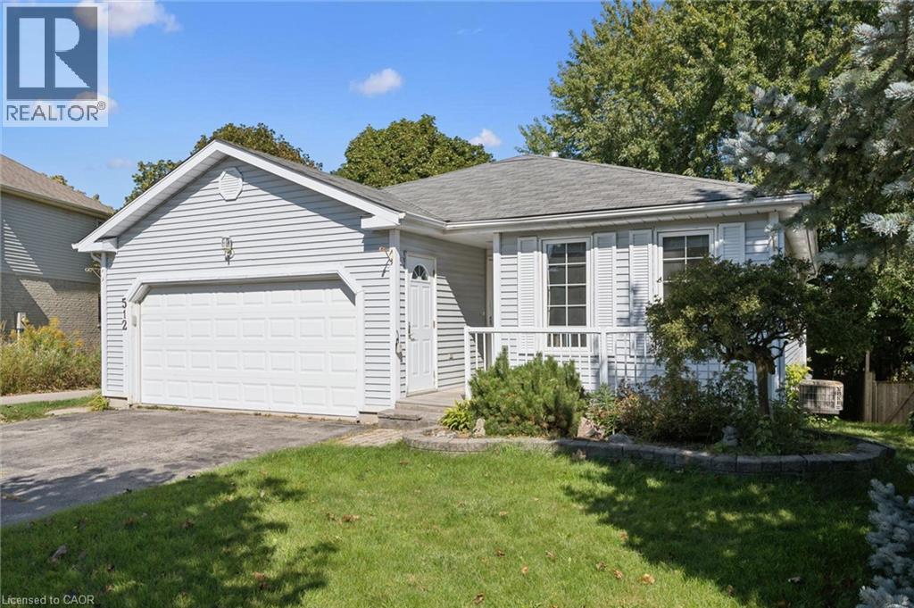 Light gray siding exterior with white trim, front porch with white railing, attached single-car garage, and established landscaping - 512 Thorndale Drive, Waterloo, ON