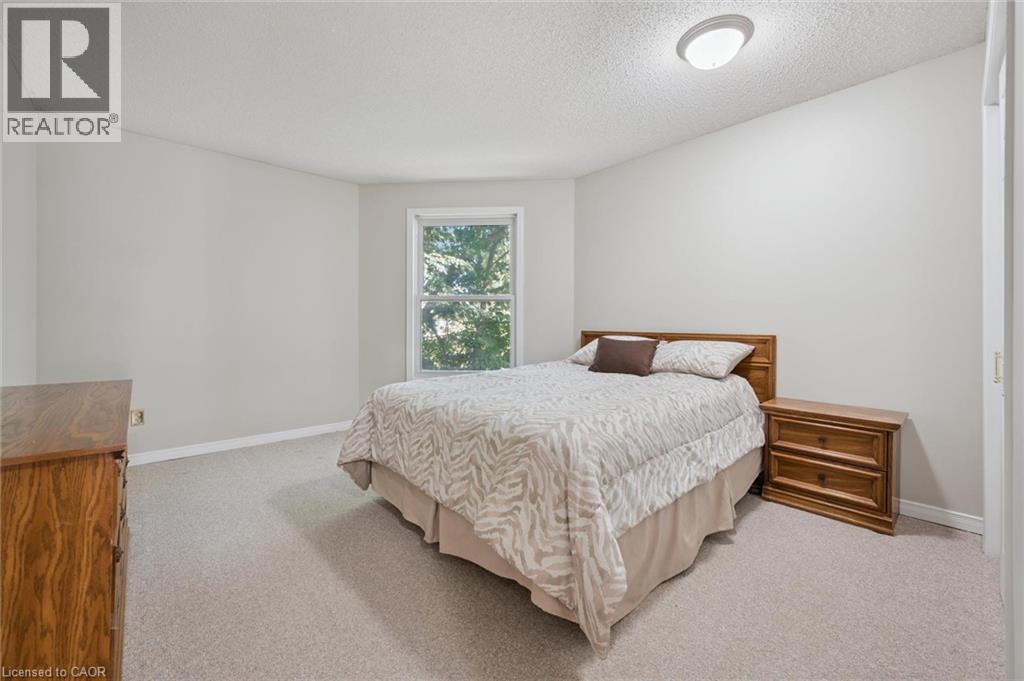 Wall-to-wall carpeting, neutral wall color, and a window with natural light - 512 Thorndale Drive, Waterloo, ON