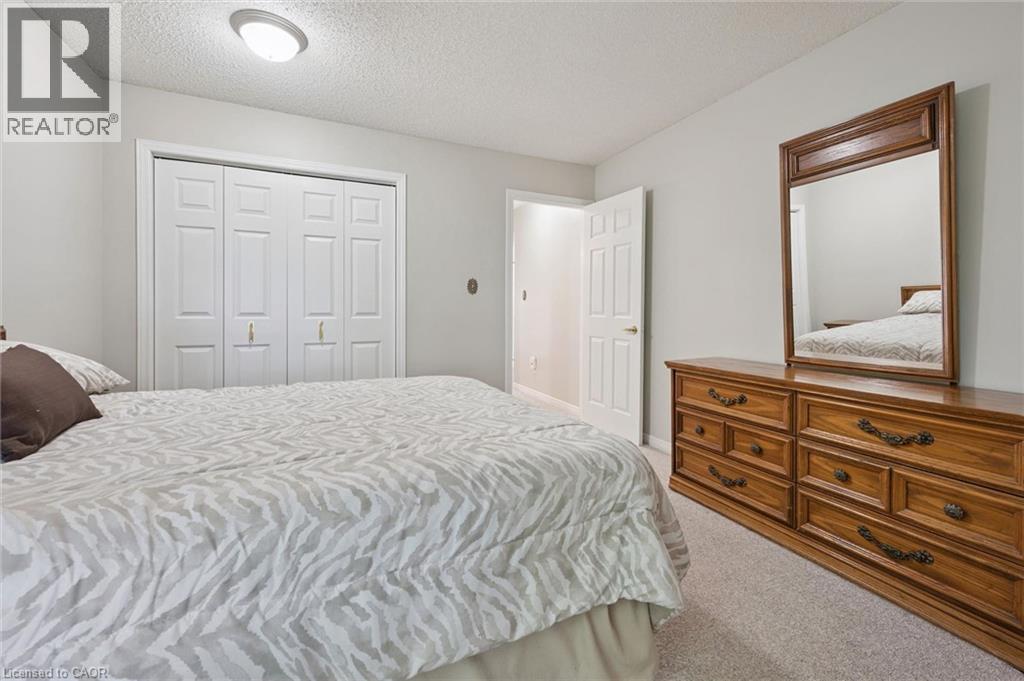 Carpeted flooring, bi-fold closet doors, flush mount ceiling lighting, and a paneled interior door - 512 Thorndale Drive, Waterloo, ON