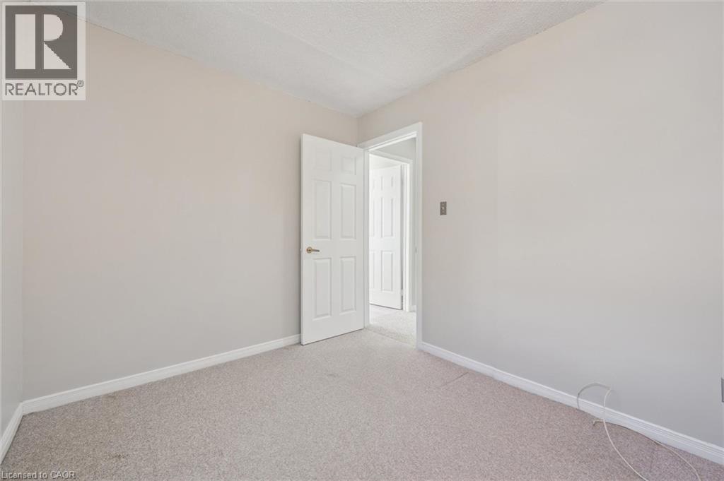 Light-colored carpeting, neutral wall paint, and a textured ceiling - 512 Thorndale Drive, Waterloo, ON