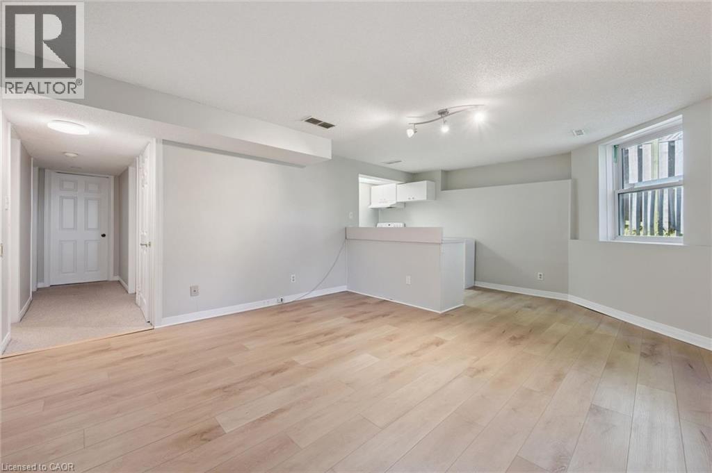 Light wood-finish flooring with white baseboards - 512 Thorndale Drive, Waterloo, ON