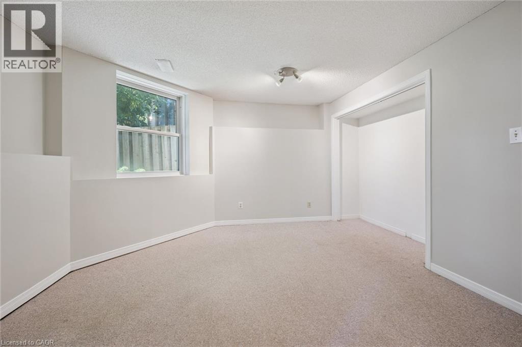 Recessed window, track lighting, neutral wall tones, light-toned carpeting, and an open doorway - 512 Thorndale Drive, Waterloo, ON
