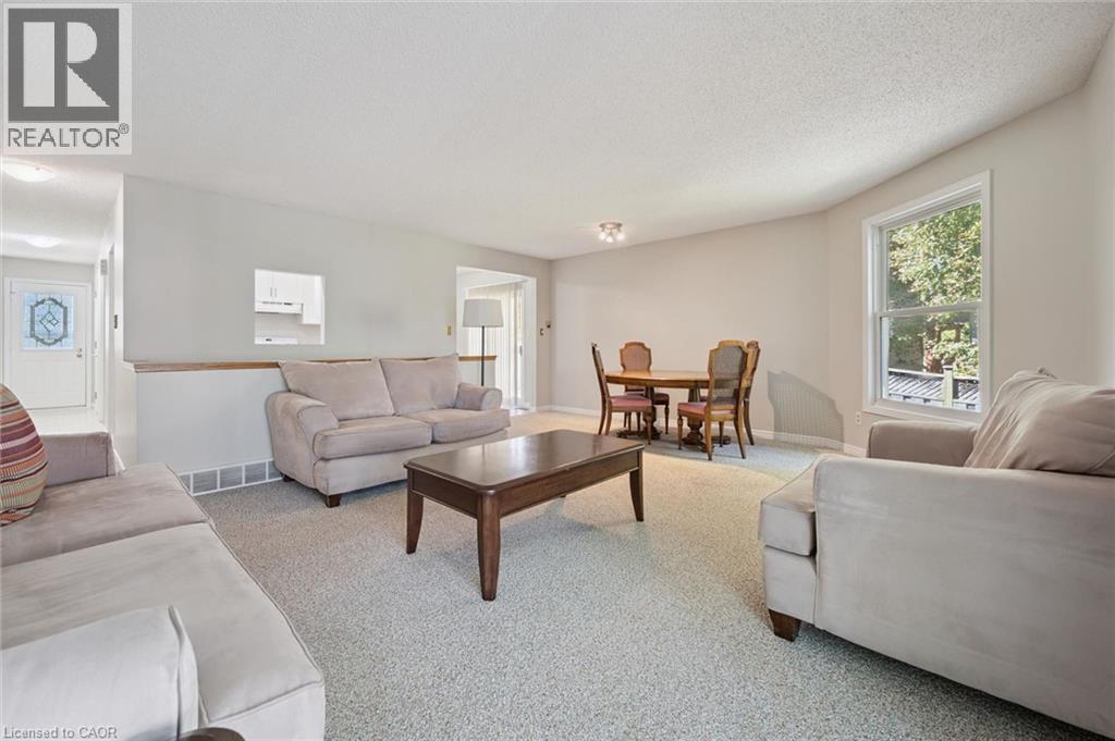 Open concept living area with light-colored walls and soft textured carpeting - 512 Thorndale Drive, Waterloo, ON