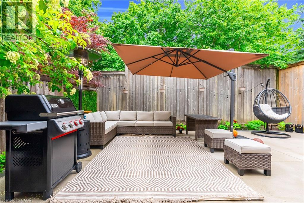 Concrete patio with a privacy fence and mature perimeter plantings - 2435 Coho Way, Oakville, ON