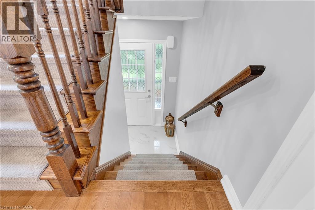 Staircase featuring wood railings and carpeted treads - 2435 Coho Way, Oakville, ON