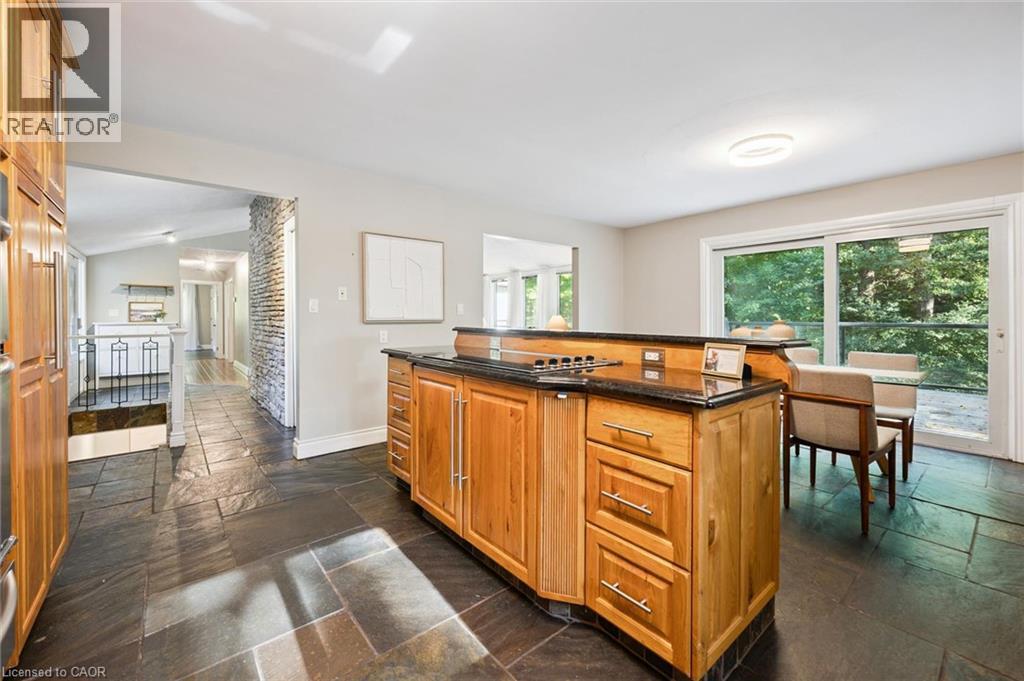 Kitchen island with a built-in cooktop, dark countertop, and wood cabinetry - 282 Concession Rd 2, Scotland, ON