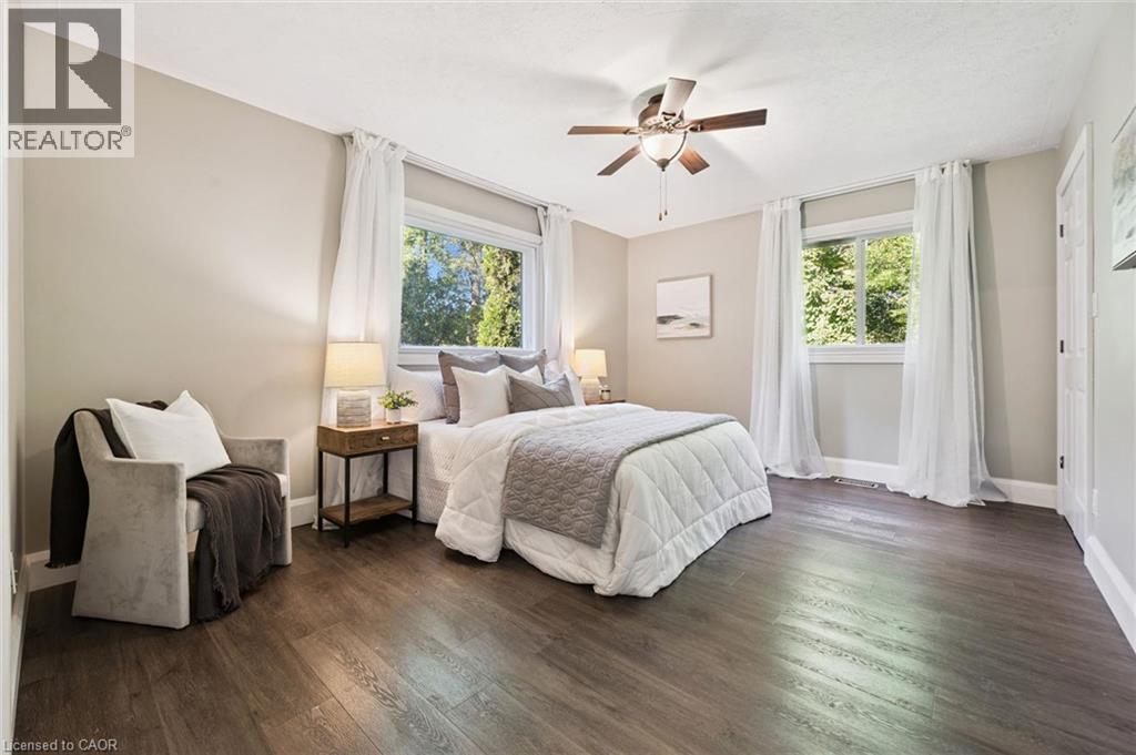 Wood-finish flooring, two windows with white trim, ceiling fan with light fixture, and light-toned walls - 282 Concession Rd 2, Scotland, ON