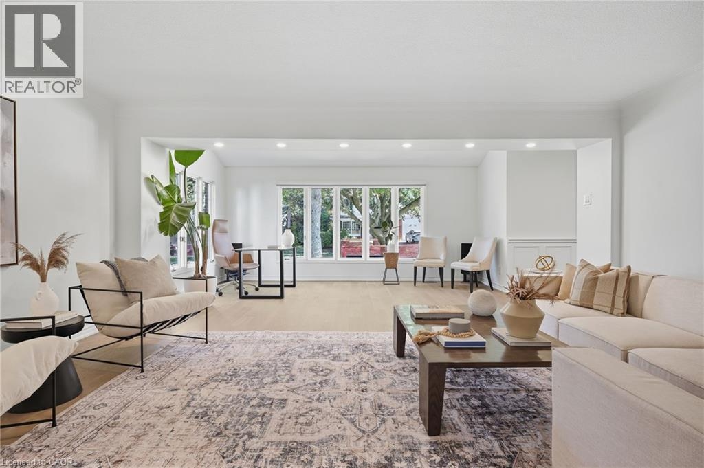 Recessed lighting, wood-finish flooring, and white walls with trim detailing define this expansive interior space - 4159 Spruce Avenue, Burlington, ON