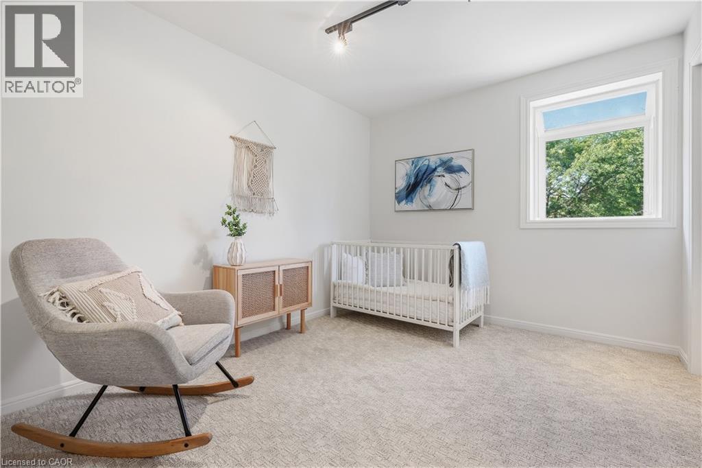 White painted walls, track lighting, and a single window with white trim, and light-colored carpeting - 4159 Spruce Avenue, Burlington, ON