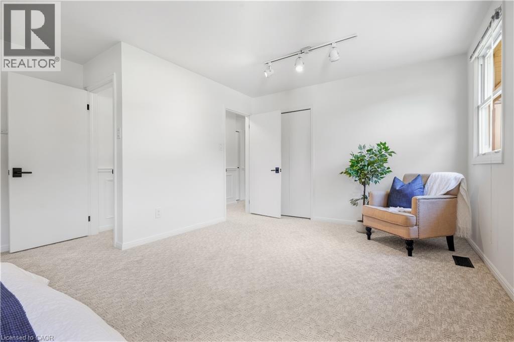 Recessed window, track lighting fixture, light-colored carpeting, white walls, and white doors with matte black hardware - 4159 Spruce Avenue, Burlington, ON