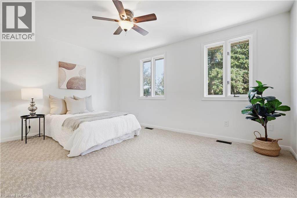 Neutral-toned carpeting, white walls, and a ceiling fan with integrated lighting - 4159 Spruce Avenue, Burlington, ON