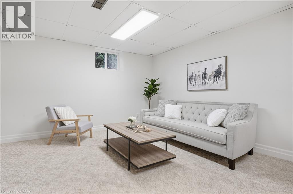 Recessed lighting, light-toned carpeting, and a window for natural illumination - 4159 Spruce Avenue, Burlington, ON