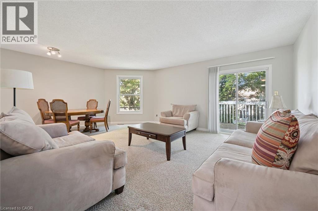 Neutral wall color throughout, carpeted flooring, built-in track lighting, sliding glass door with balcony access, and a single pane window - 512 Thorndale Drive, Waterloo, ON