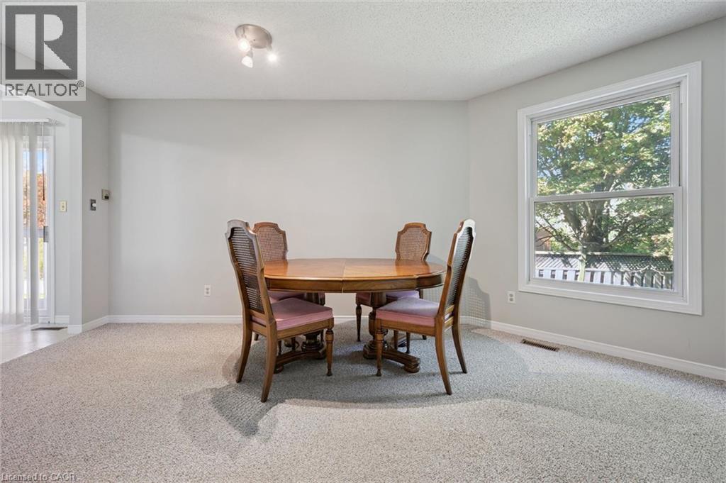Spacious room featuring light gray walls, light gray carpet, and a large window with white trim - 512 Thorndale Drive, Waterloo, ON
