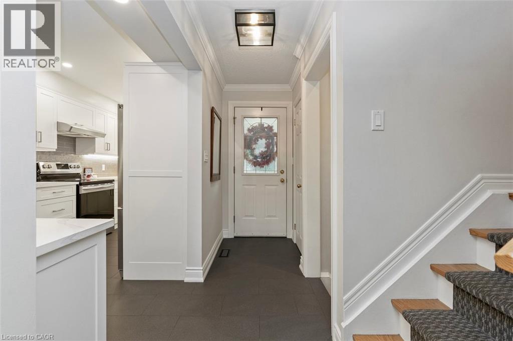 U-shaped kitchen (2022) with white cabinetry, quartz counters and stainless steel appliances - 200 Woodview Crescent, Ancaster, ON