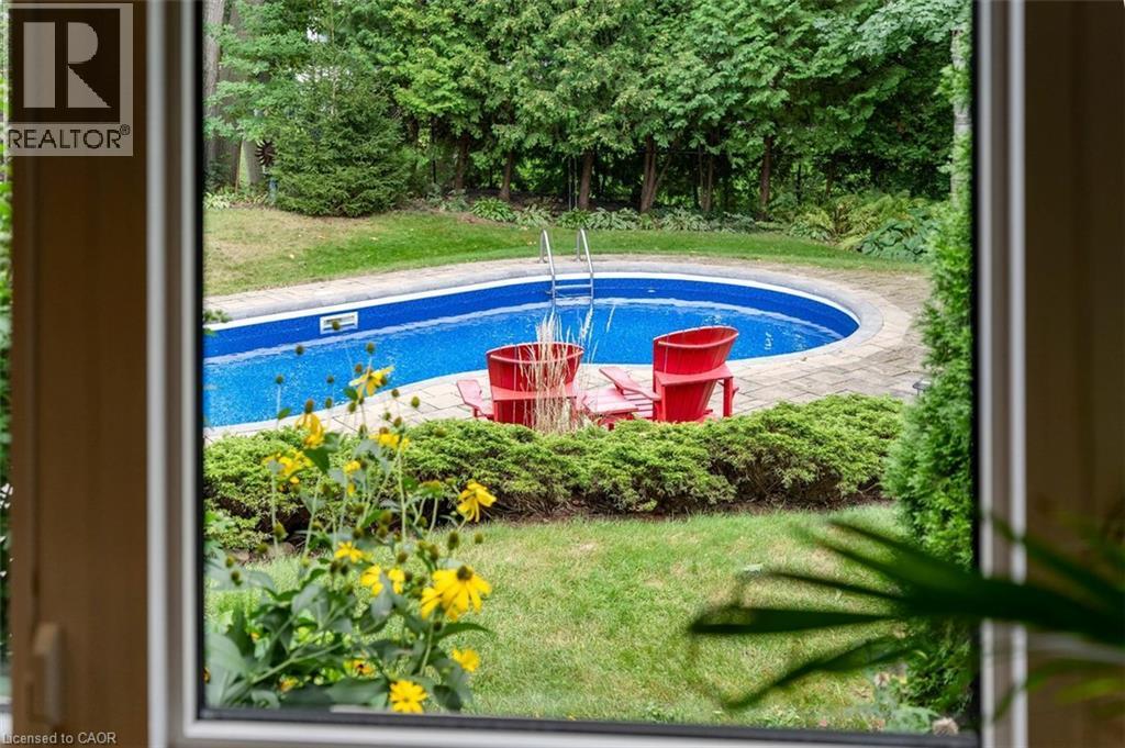 Living room with hardwood flooring, gas fireplace and views of mature trees in backyard - 200 Woodview Crescent, Ancaster, ON